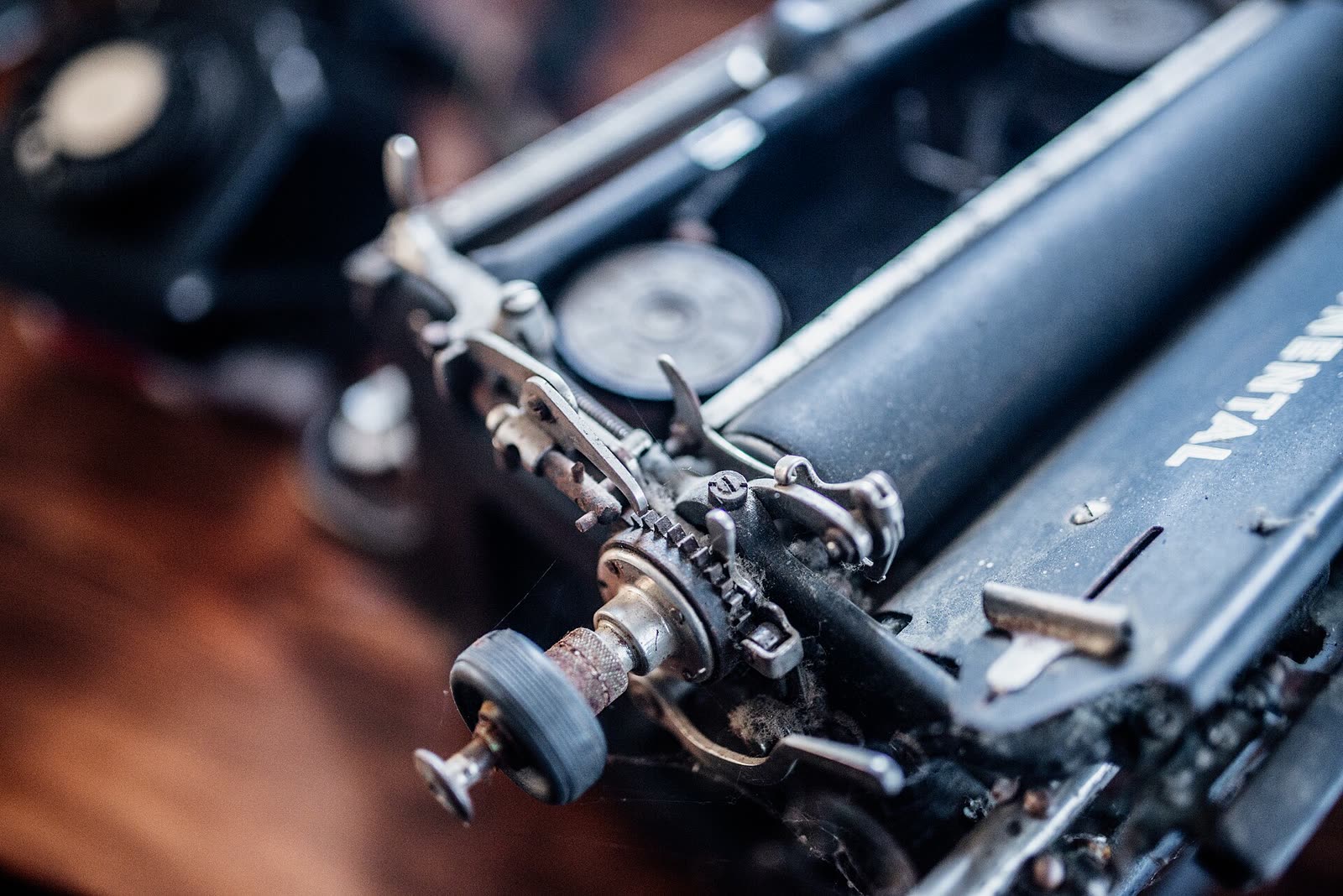 Detalle de una máquina de escribir Continental: el rodillo y sus engranajes, cubiertos de polvo